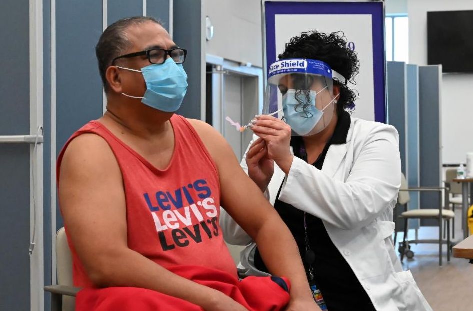 Patient receiving a vaccine from a caregiver