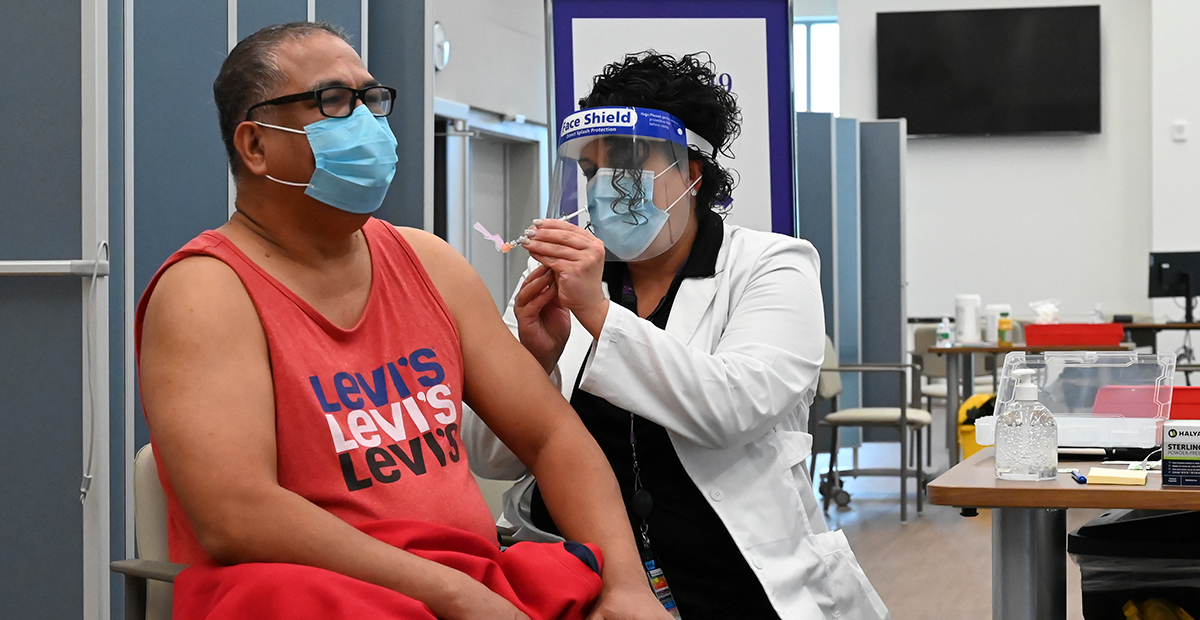 Caregiver giving a patient a vaccine