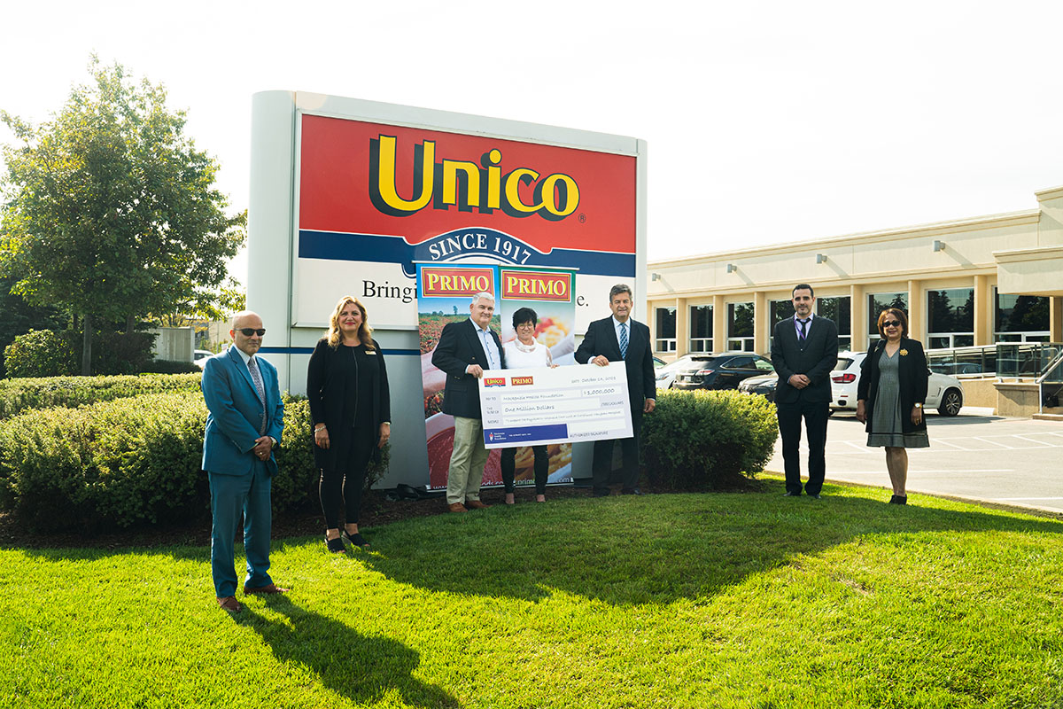 The family and Mackenzie Health team holding up a large cheque in front of the Unico sign